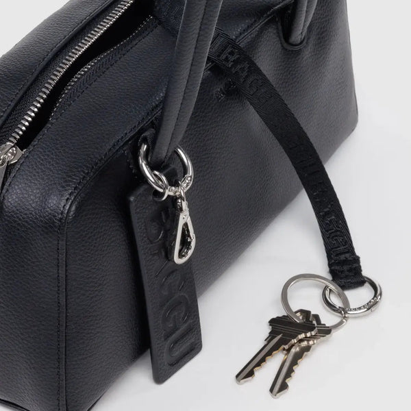 Black handbag with a keychain featuring keys on a white background