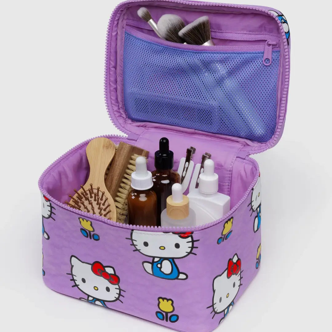Purple cosmetic bag with Hello Kitty designs containing various items on a white background