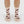 Beige socks with horse pattern worn by a person on a white background