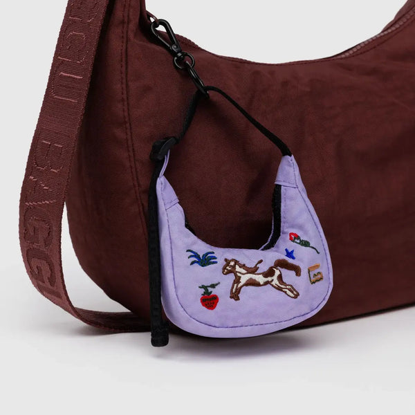 Brown handbag with a purple mini bag featuring a horse design on a white background