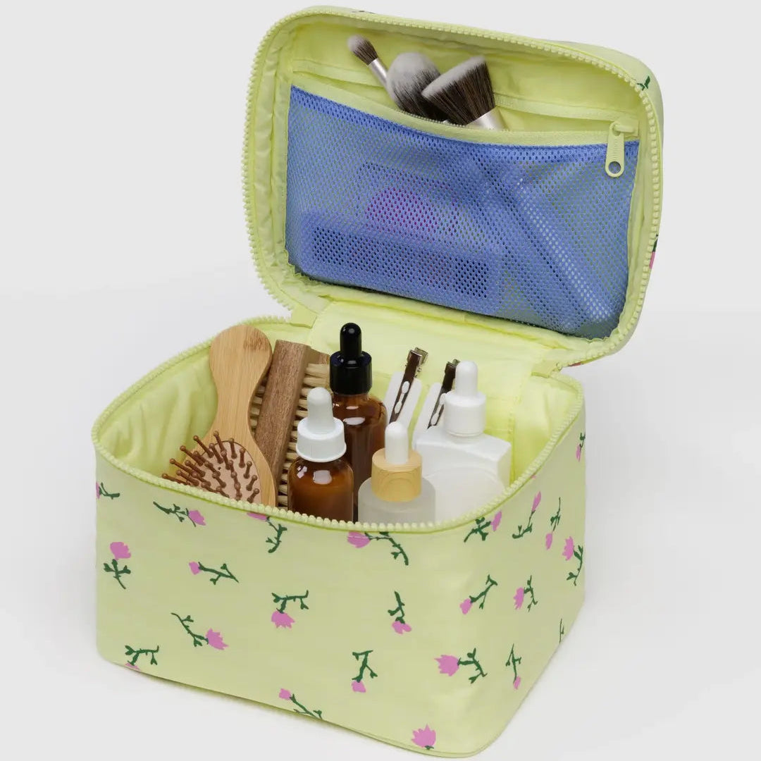 Small travel case with floral pattern containing beauty products on a white background