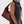 Person holding a maroon handbag against a white background