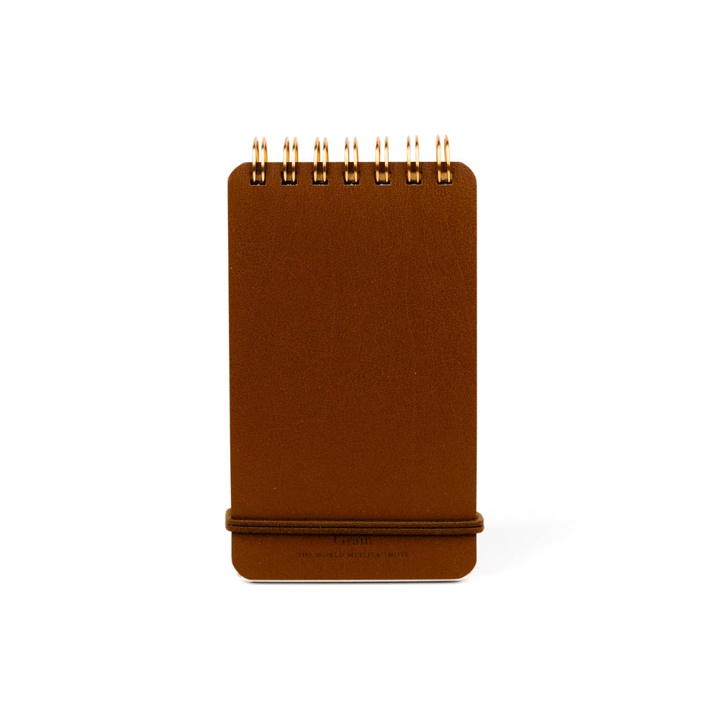 Brown memo notebook with gold spiral binding on a white background