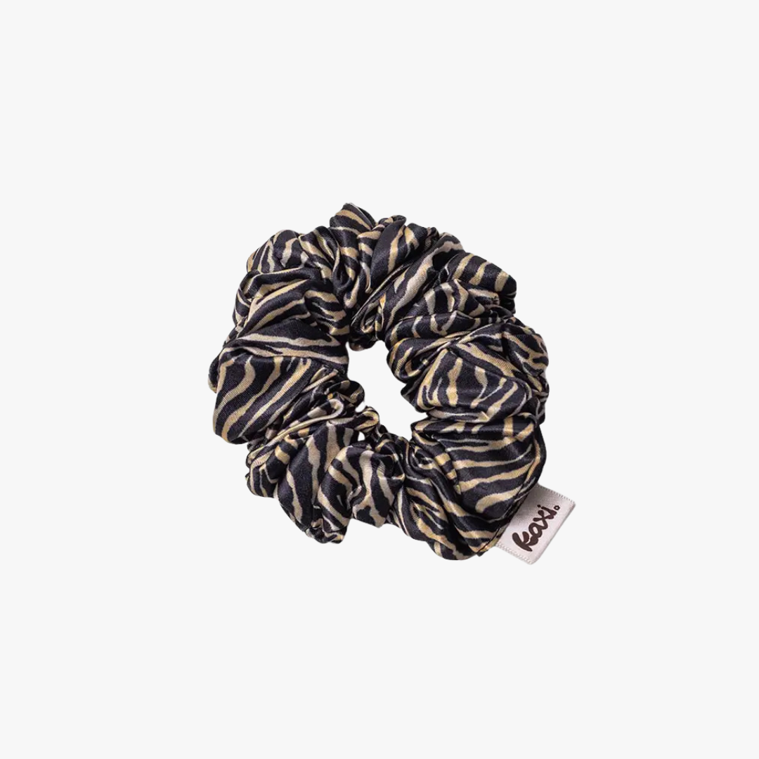 A black and beige zebra-print fabric scrunchie with a small white brand tag that reads 'box', shown on a plain light gray background.