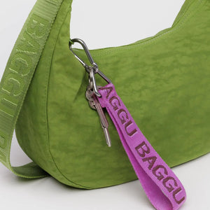 Green bag with a pink 'BAGGU' keychain on a white background