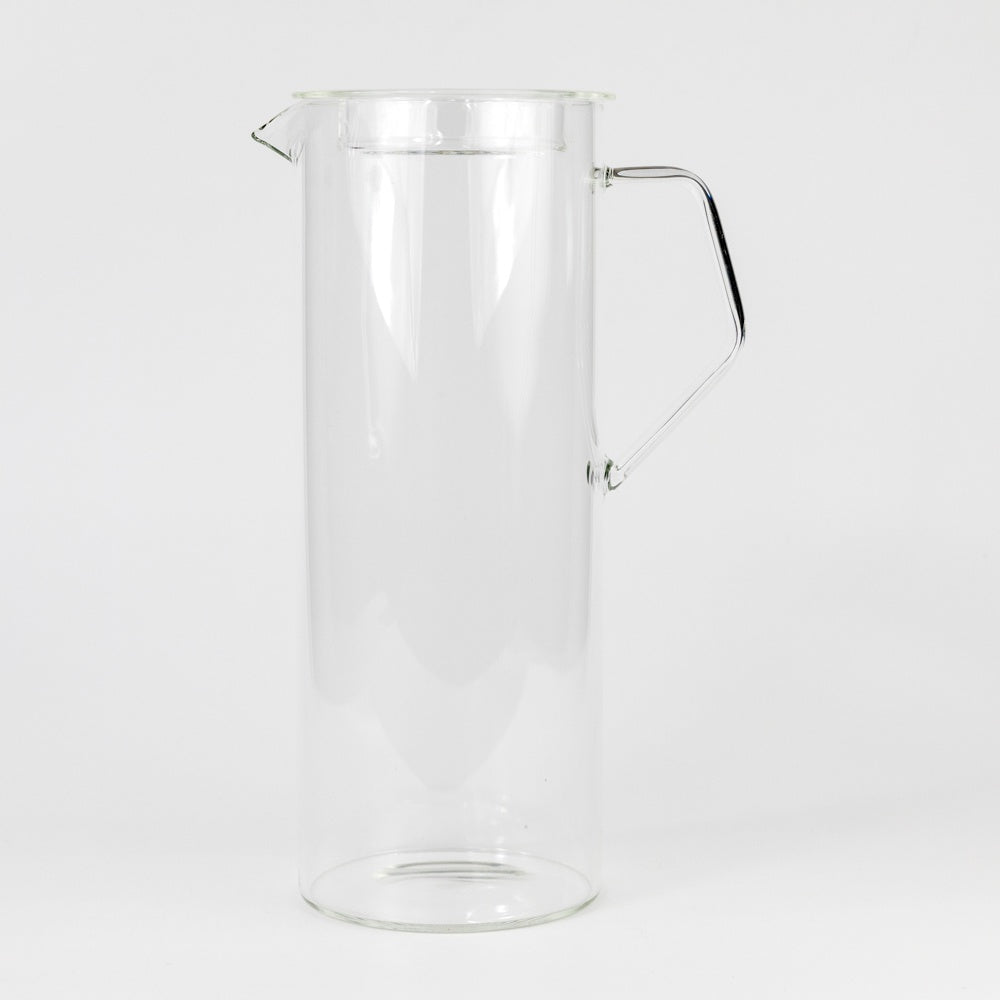 Clear glass pitcher with handle on a white background