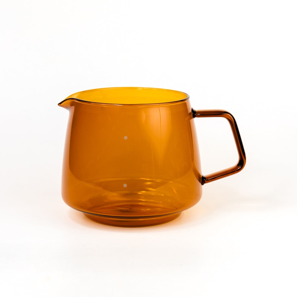Amber-colored glass pitcher on a white background