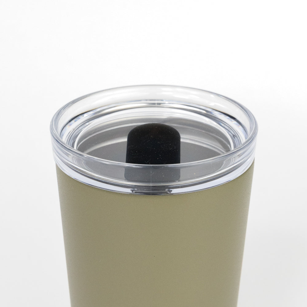 Green tumbler with a clear lid on a white background