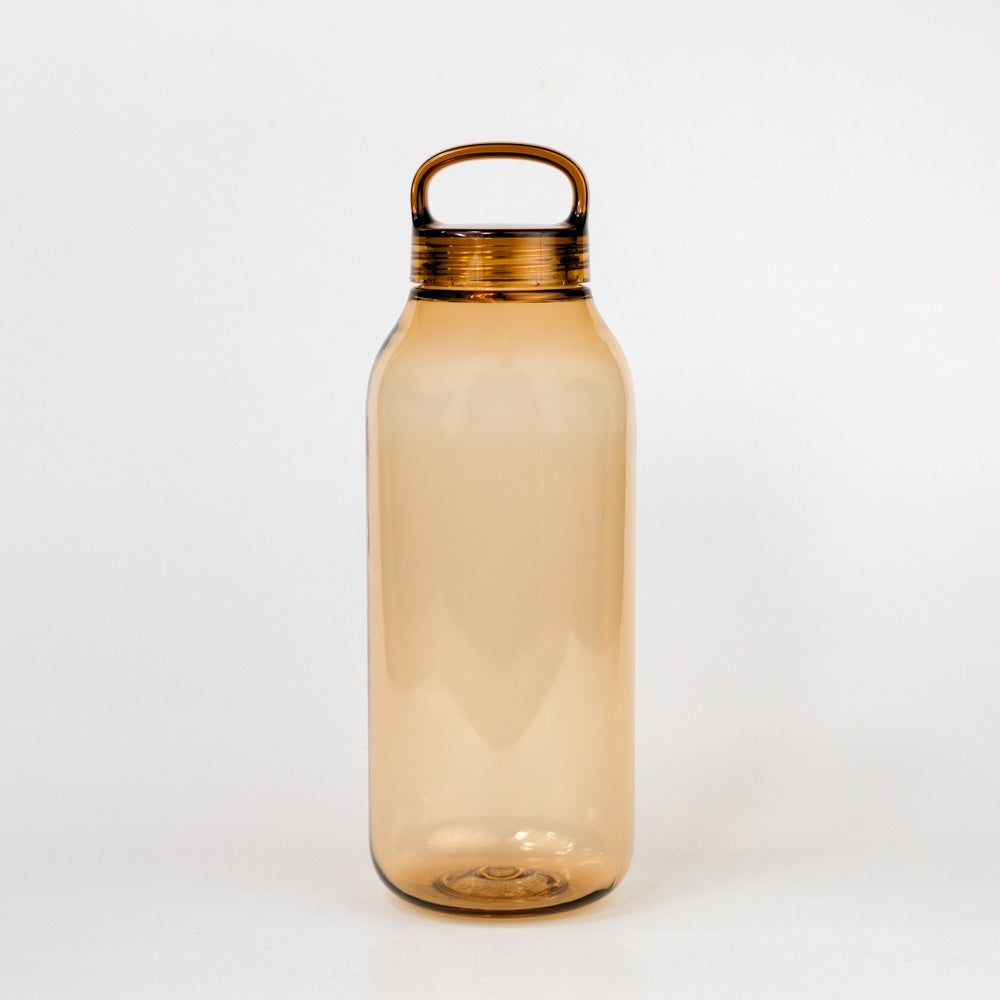 Amber glass water bottle with a bronze cap on a white background