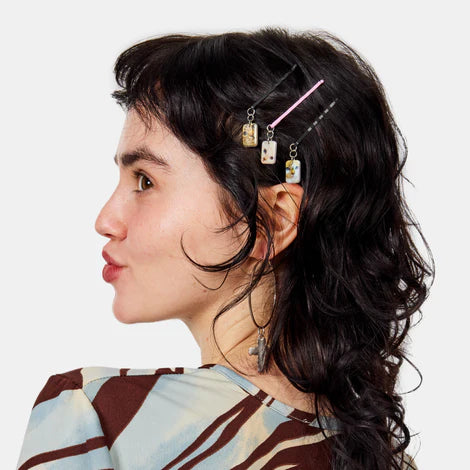 Person with decorative hair pins in their hair against a white background