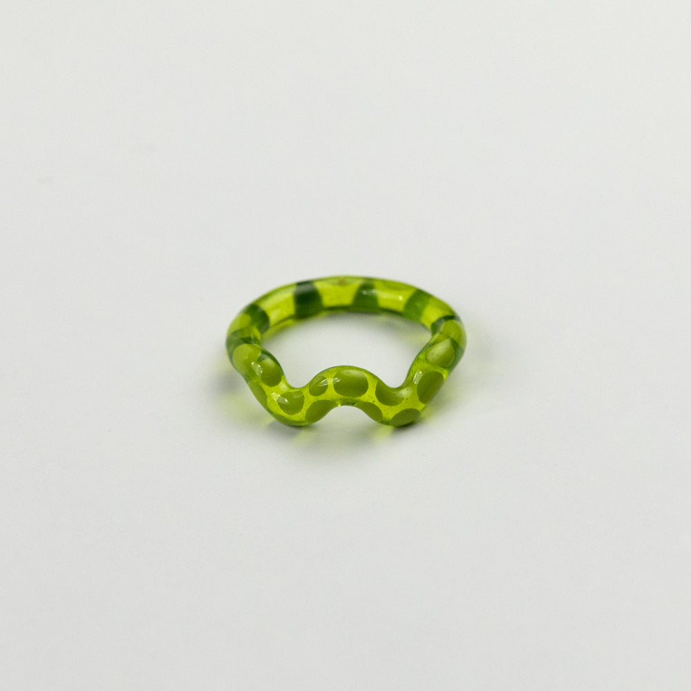 Green ring with a unique design on a light gray background