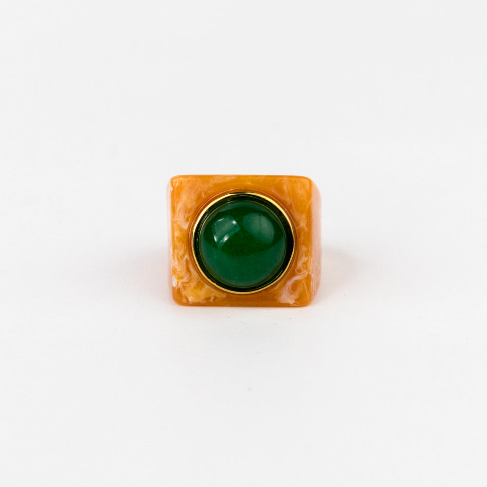 Ring with a green gemstone and gold band on a white background