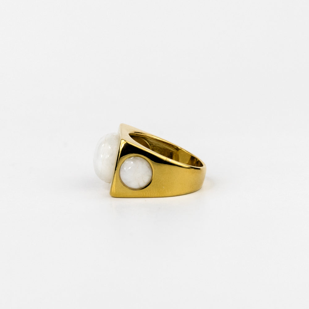 Gold ring with a white gemstone on a white background