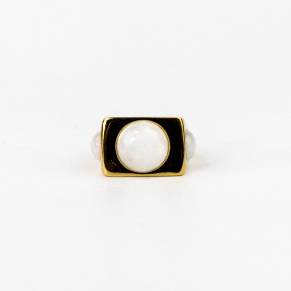 Ring with a white gemstone and gold border on a white background