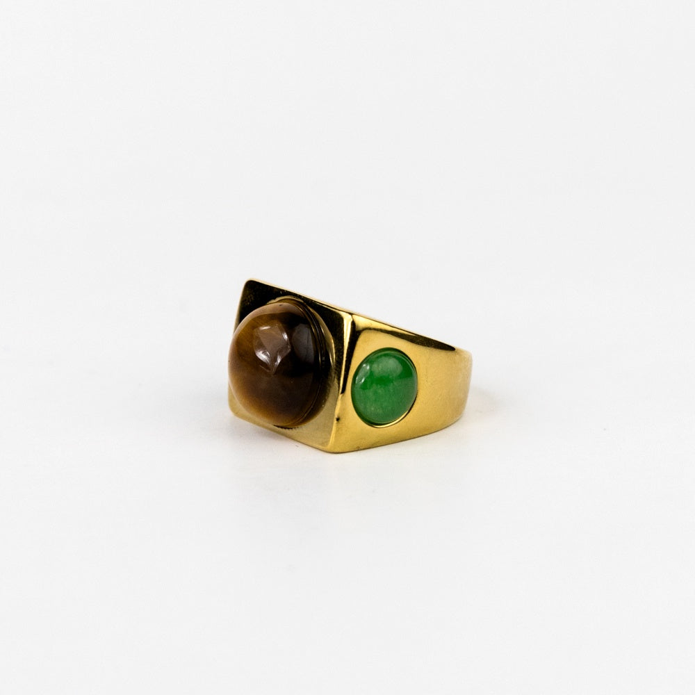 Gold ring with a green gemstone and brown stone on a white background
