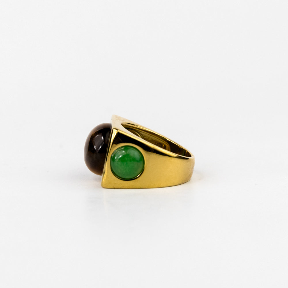 Gold ring with green and brown gemstones on a white background