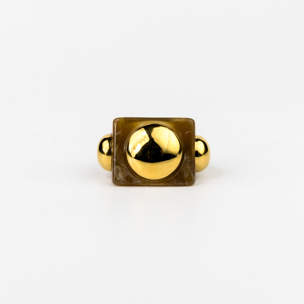 Gold ring with a square setting and spherical stones on a white background