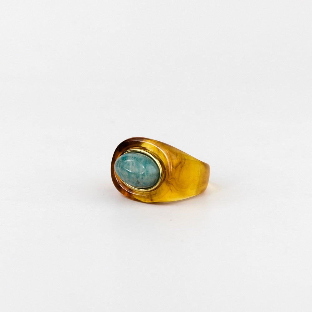 Gold ring with a green gemstone on a white background
