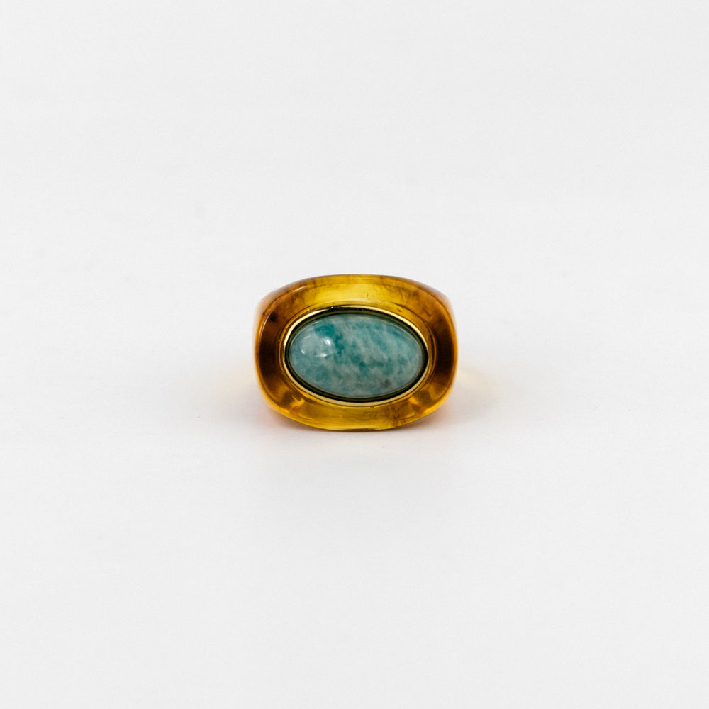 Gold ring with a green gemstone on a white background
