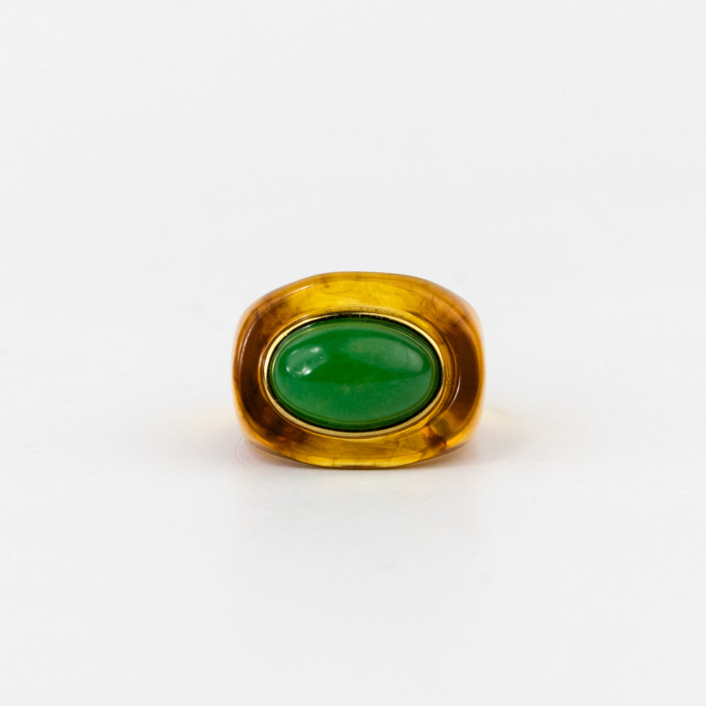 Gold ring with a green gemstone on a white background