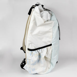Light blue backpack with a white drawstring bag on a gray background