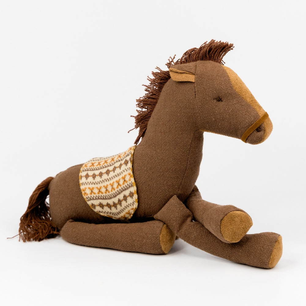 Brown plush horse toy with a saddle blanket on a white background