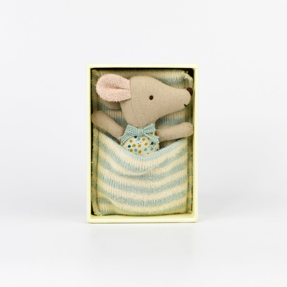 Stuffed mouse toy in a striped box on a white background