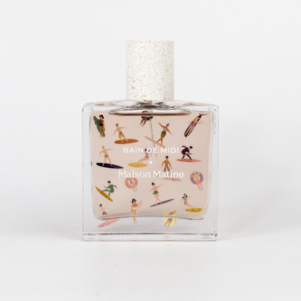 Perfume bottle with beach-themed design on a white background