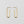 Elongated gold hoop earrings on a light gray background