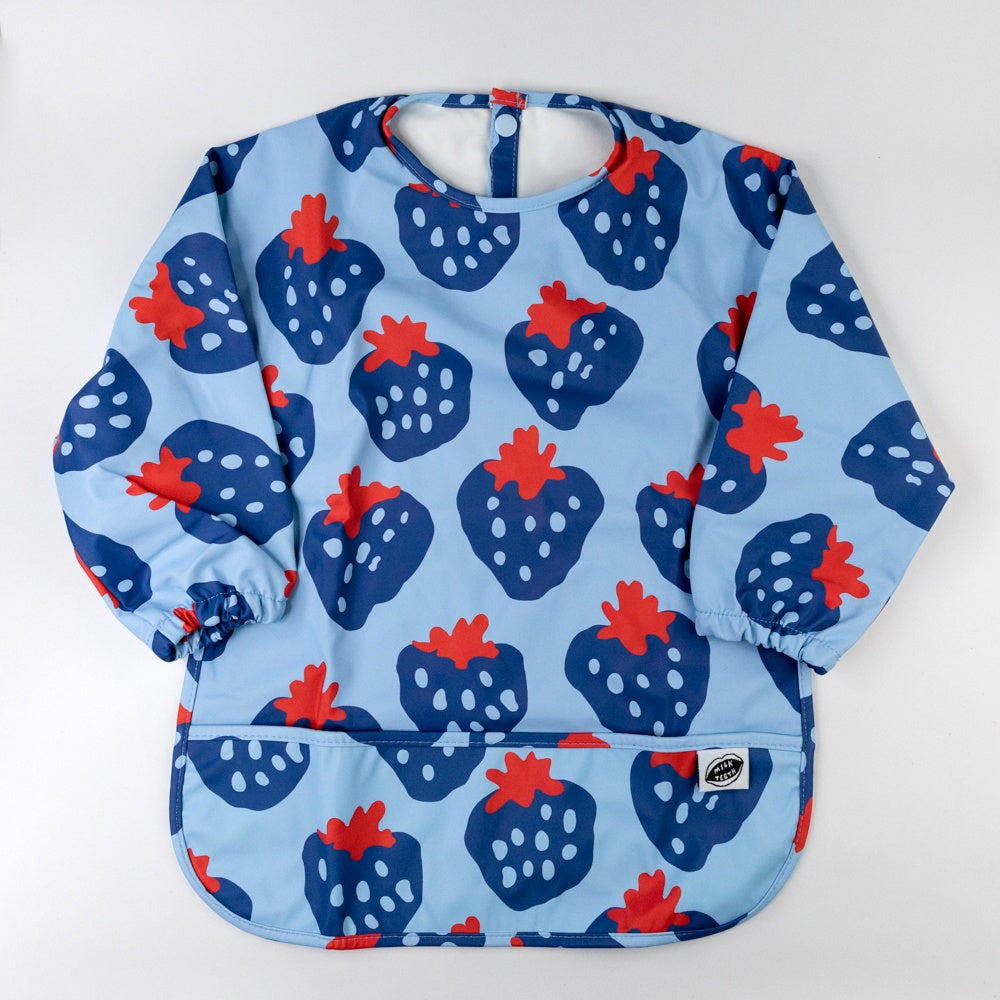 Children's smock bib with strawberry pattern on a light blue background
