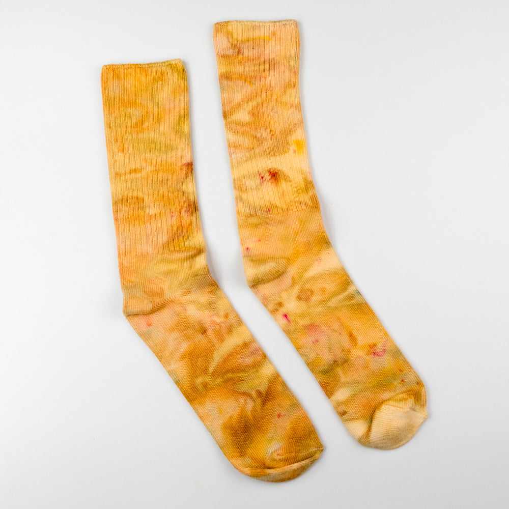 Pair of orange tie-dye socks on a white background