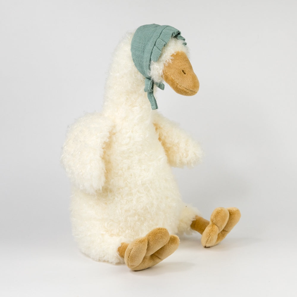 Plush toy goose with a green bonnet on a white background