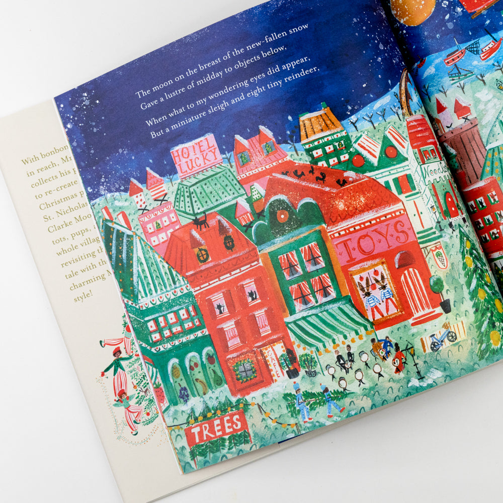 Illustrated book page with a festive town scene on a snowy night.