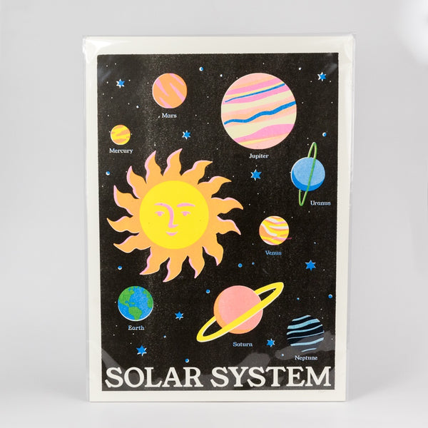 Risograph art print of the solar system with colorful planets and sun on a black background
