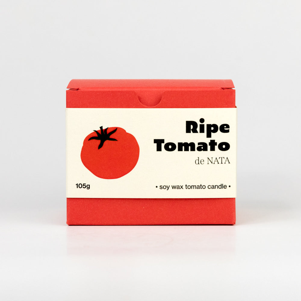 Tomato-shaped candle with green stem on a white background