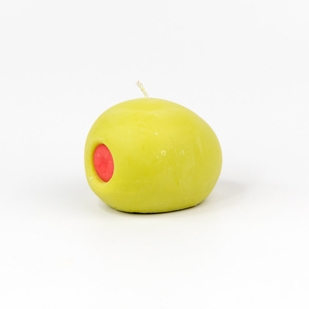 A green olive with red pimento shaped candle