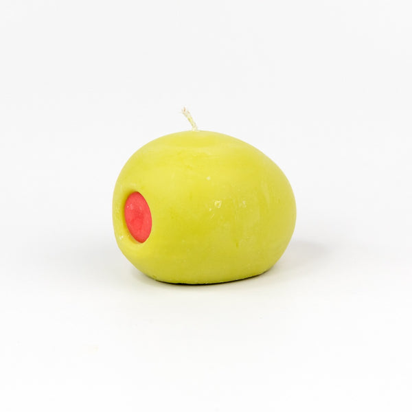 A green olive with red pimento shaped candle