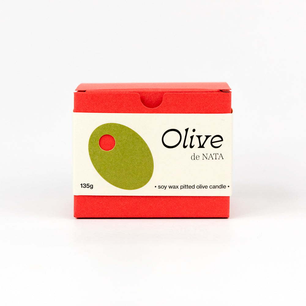 A green olive with red pimento shaped candle