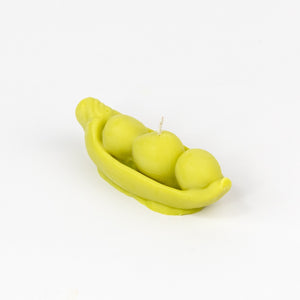 Pea pod candle with three peas on a white background