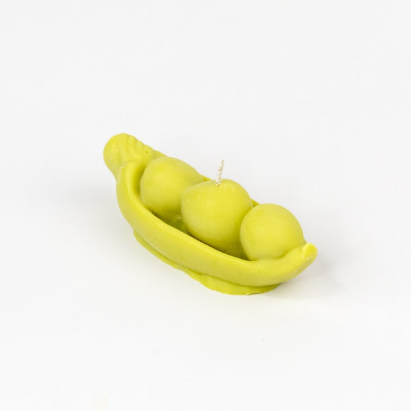Pea pod candle with three peas on a white background