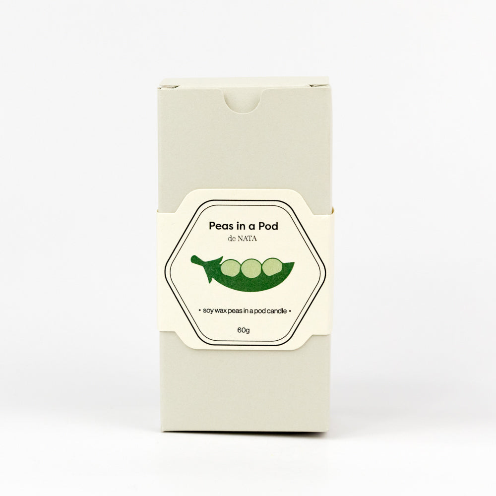 Pea pod candle with three peas on a white background