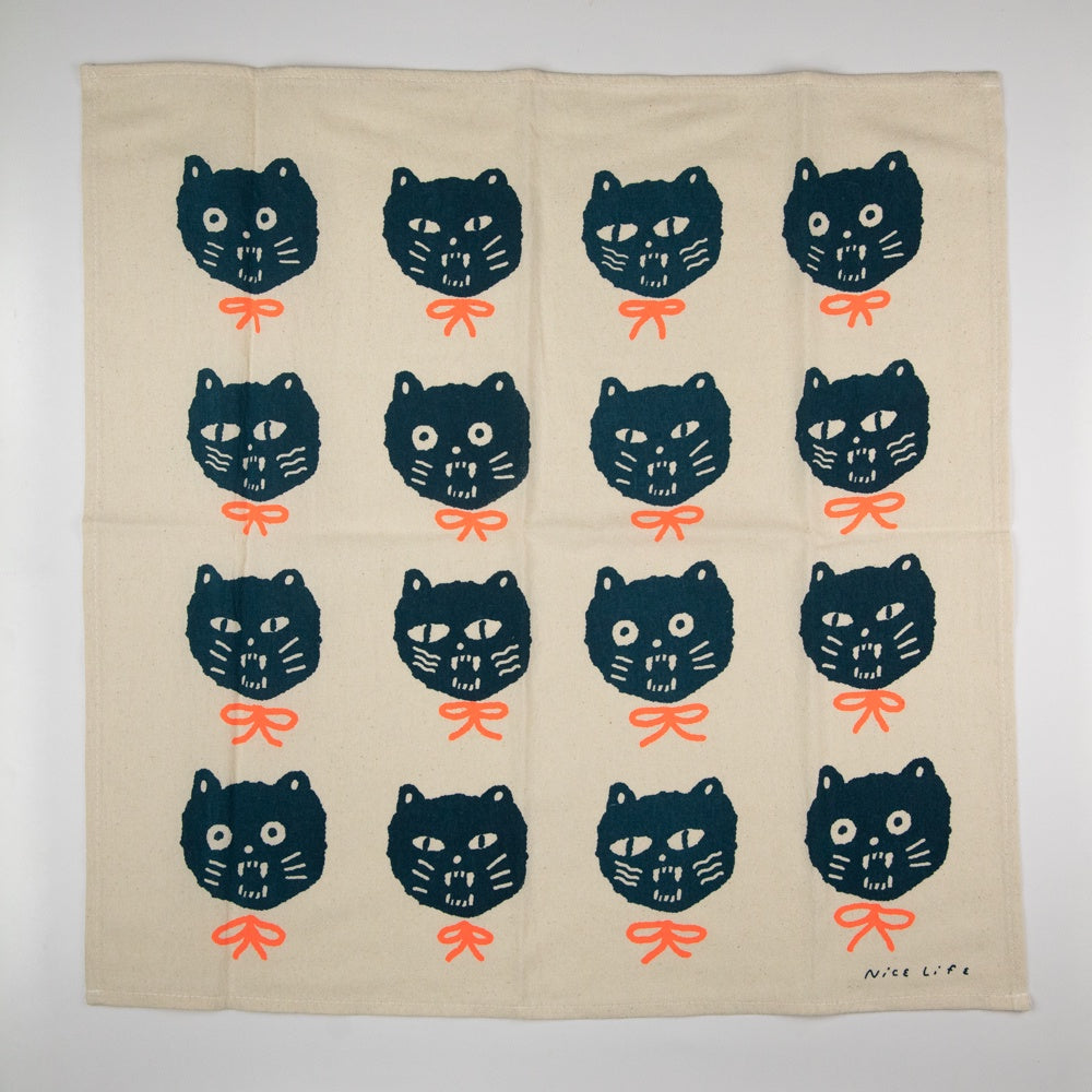 Beige towel with black cat faces and orange bows pattern