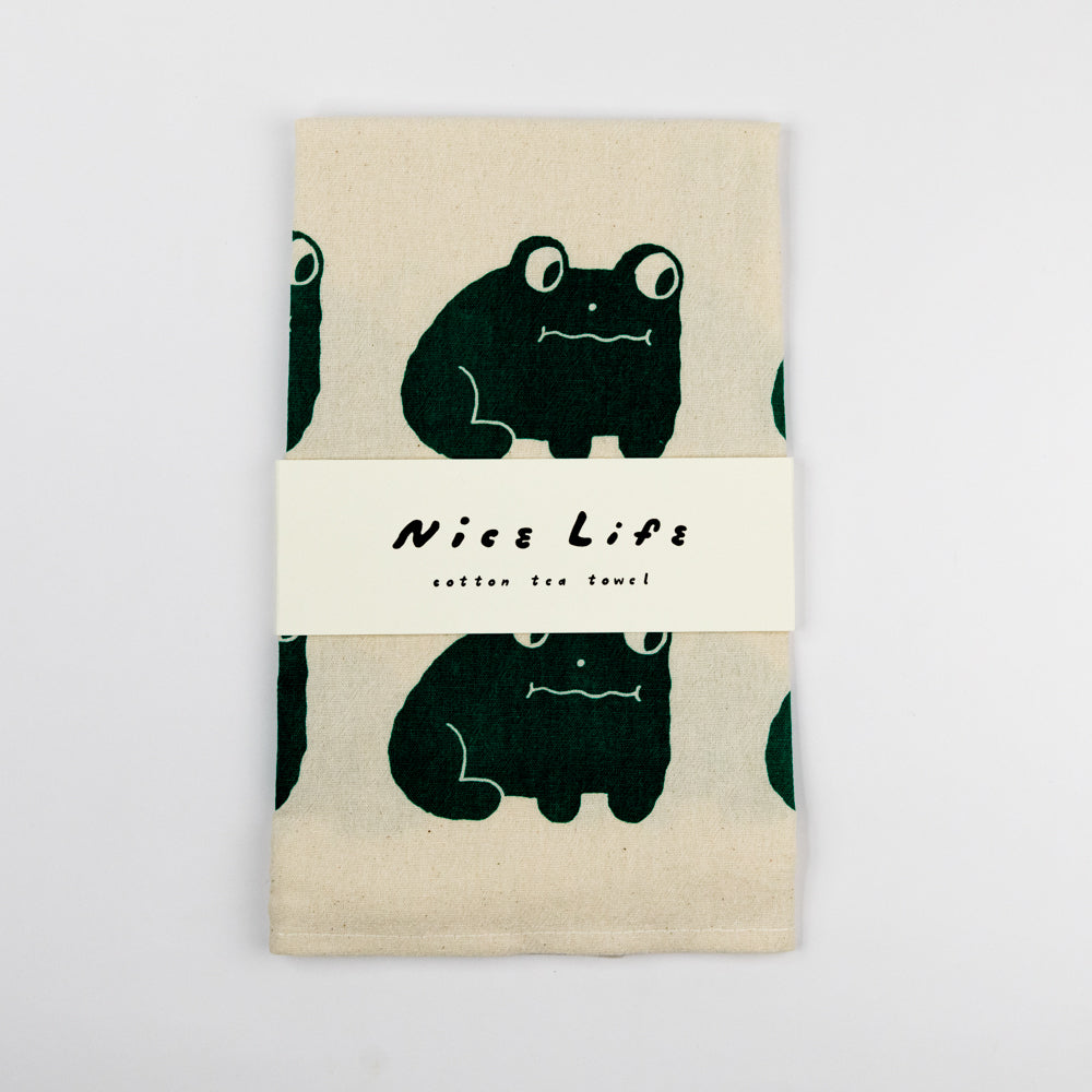 Beige towel with green frog pattern on a white background