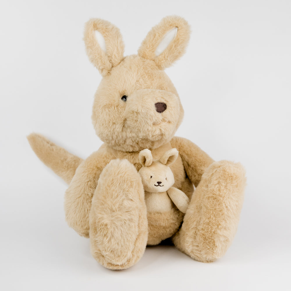 Beige plush kangaroo holding a smaller beige plush kangaroo in its pouch on a white background