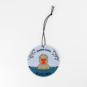 Round hanging flat disc with a monkey illustration and text on a white background