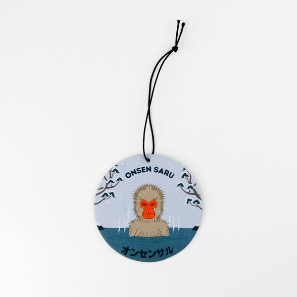 Round hanging flat disc with a monkey illustration and text on a white background