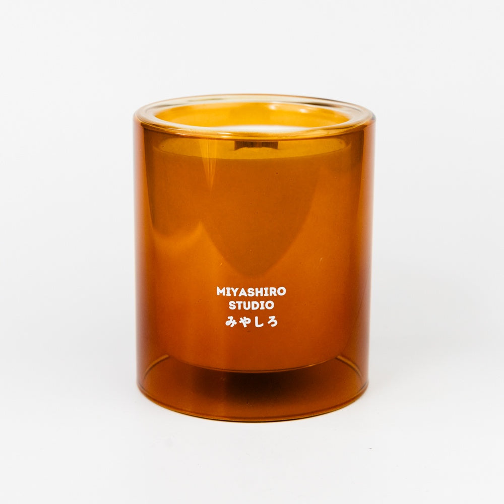 Amber glass candle with 'MIYASHIRO STUDIO' branding on a white background