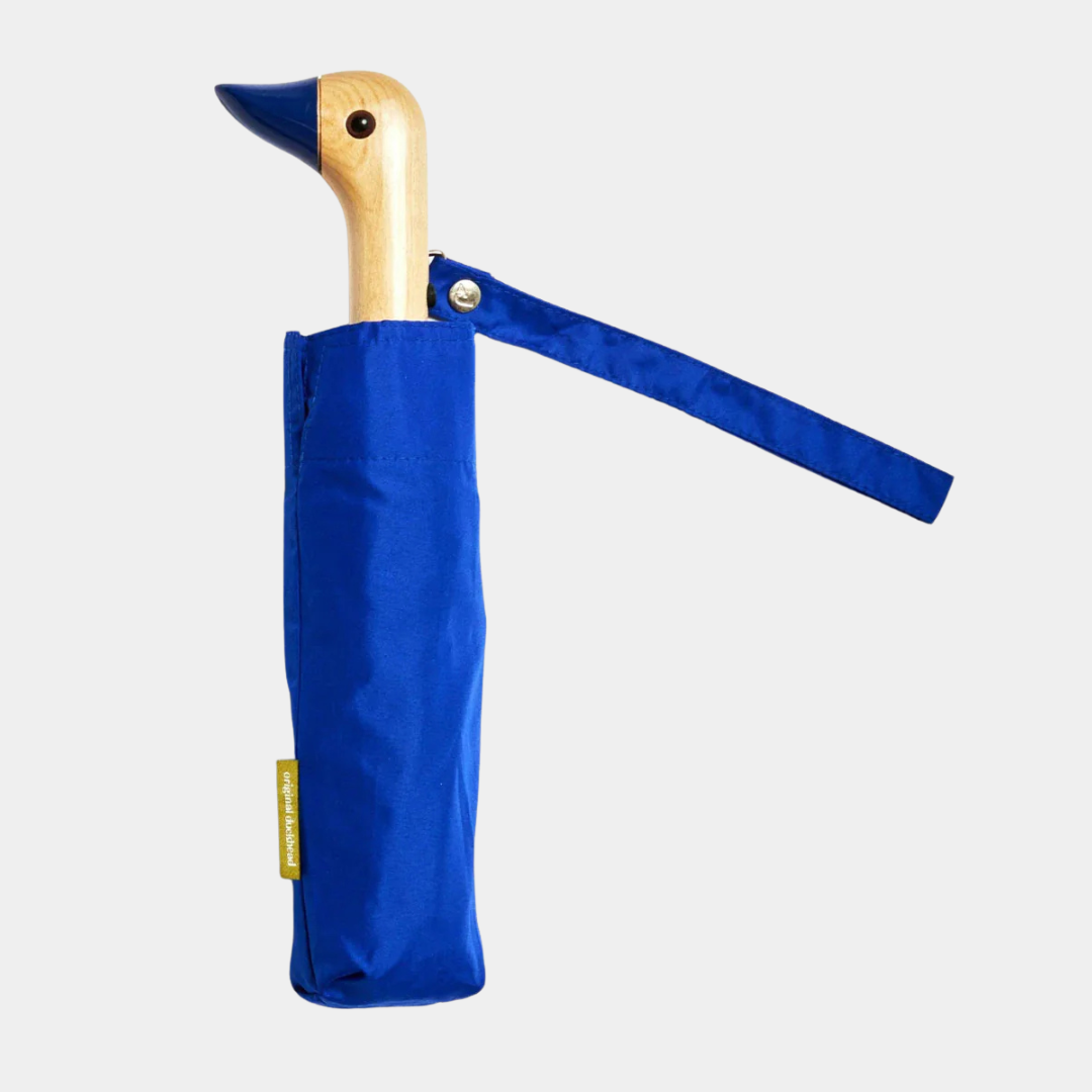 Blue umbrella with wooden handle on a light gray background