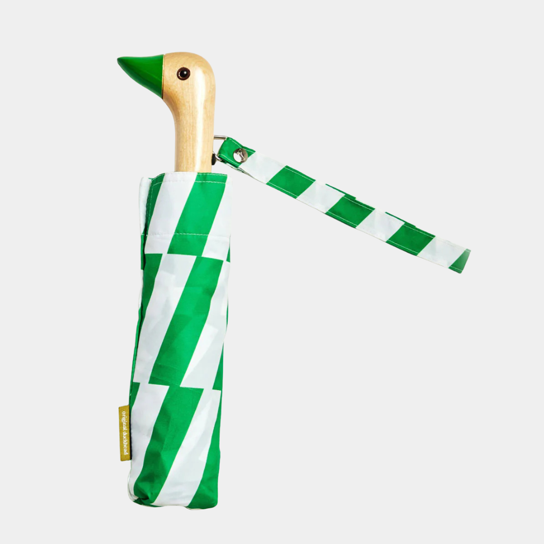 Green and white striped umbrella with wooden handle on a light gray background