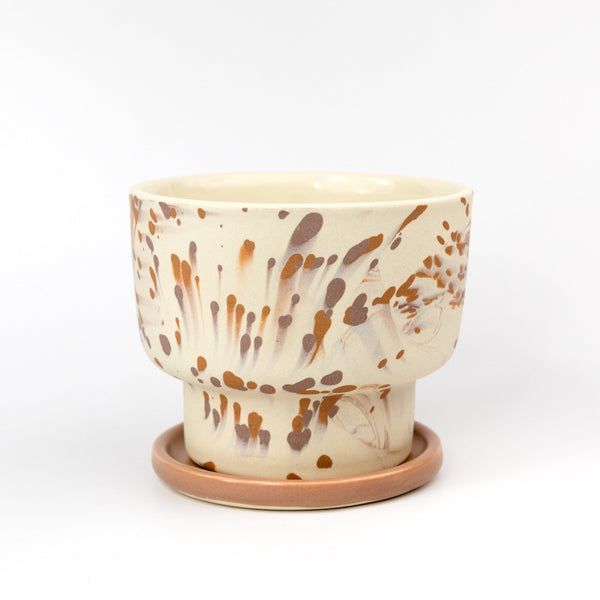 Ceramic pot with brown and beige speckled design on a white background